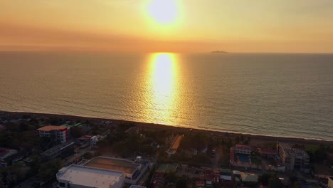Filmischer-Drohnenschuss,-Der-Eine-Asiatische-Küstenstadt-Am-Meer-Während-Der-Goldenen-Stunde-Zeigt
