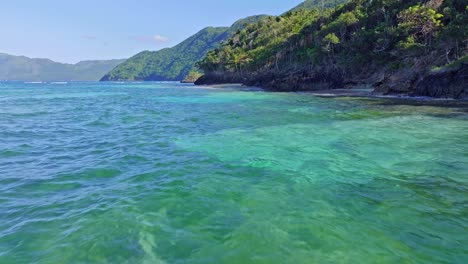 Slow-forward-flight-over-crystal-clear-Caribbean-sea-along-coastline