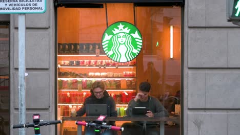 Kunden-Trinken-Und-Benutzen-Laptops-Im-Coffee-Store-Der-Amerikanischen-Multinationalen-Kette-Starbucks