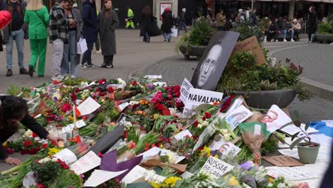 Menschen-Gedenken-Des-Todes-Von-Alexei-Nawalny-In-Der-Öffentlichkeit-Auf-Dem-Dam-Platz-Mit-Blumen-Und-Teelichtern,-Protestieren-Gegen-Mord
