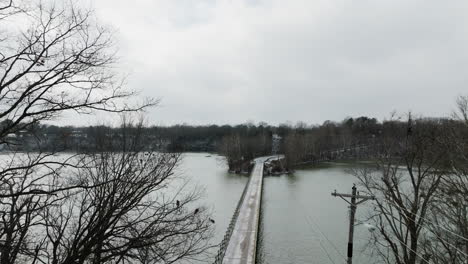 Aerial-view-of-bridge-in-Lake-Sequoyah-in-winter,-lowering,-grey-cloudy-sky