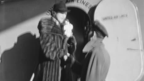 Woman-in-Fur-Coat-Says-Goodbye-to-Man-at-Airplane-Door-in-1930s