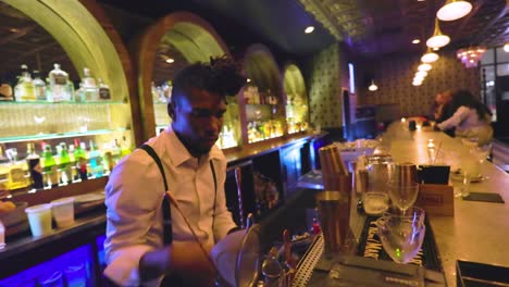 black-male-bartender-is-pouring-a-crafted-cocktail-in-a-glass-to-serve-to-customer-a-local-bar