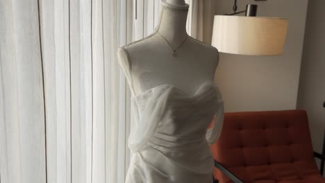 Weißes-Brautkleid-Auf-Einer-Schaufensterpuppe-Neben-Einem-Großen-Fenster-Im-Hotelzimmer