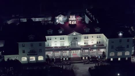 Vista-Aérea-De-Alto-ángulo-Del-Hotel-Por-La-Noche-Iluminada-Por-La-Iluminación-Del-Gran-Ventilador