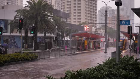 Blick-Auf-Die-Straßenbahn,-Die-An-Einer-Station-Entlang-Des-Surfers-Paradise-Boulevard-Ankommt,-Während-Schwerer-Regen-Und-Stürme-Weiterhin-Die-Goldküste-In-Anhaltenden-Stürmen-Und-Überschwemmungen-Peitschen