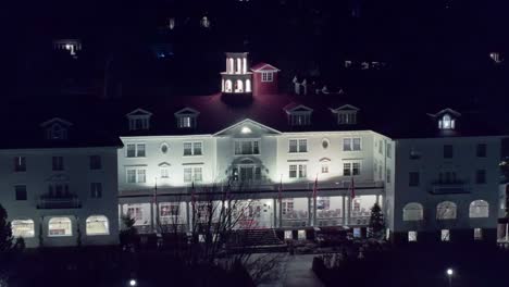 Drone-pullback-from-bell-tower-on-top-of-old-historical-white-hotel-at-night