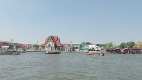 Chao-Phraya-River-boat-ride-Bangkok-Thailand-temples-near-waterbank-ProRes