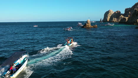 Aerial-view-around-boats-on-the-coast-of-the-arch-of-Cabo-San-Lucas,-sunny-Mexico