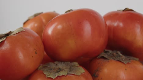 Bowl-of-persimmons-rotating-in-a-bowl-displaying-it's-sweet-bright-vibrant-orange-color