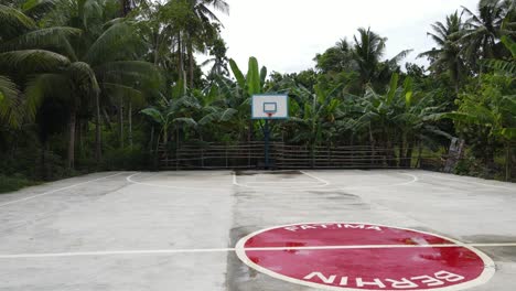 Aerial-Drone-Fly-Above-Basketball-cemented-field-around-green-tropical-jungle-of-Philippines