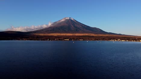 Calm-waters-of-Lake-Yamanaka-with-majestic-Mount-Fuji-in-the-backdrop,-clear-sky