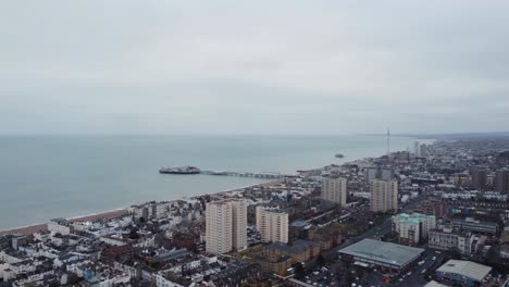 Drohnenaufnahme-Des-Strandes-Von-Brighton-An-Einem-Bewölkten-Tag,-Langsames-Einfahren-über-Wohnblöcke