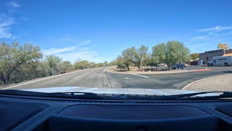 Point-of-View---Turning-into-a-parking-lot-and-driving-past-several-small-businesses-on-a-bright-sunny-day