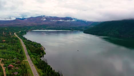 Hermoso-Lago-Claro-Con-Las-Montañas-Rocosas-Y-Las-Latas-Rodantes-Al-Fondo