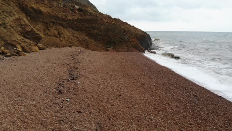 Vuelo-Aéreo-Bajo-Sobre-La-Playa-De-Seatown-En-Dorset-Hacia-La-Caída-De-Un-Gran-Acantilado-Costero