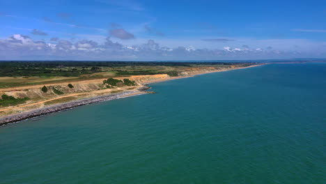 Luftaufnahmen-Vom-Meer-In-Richtung-Küste-Mit-Strand-Und-Klippen,-Sonniger-Tag,-Großbritannien,-4k