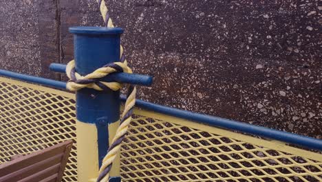 Mooring-rope-and-bollard-on-sea-water-tenses-up,-close-up