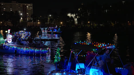 Night-Shot-Of-Christmas-Lighted-Boat-Parade-Along-River,-Tampa-Florida