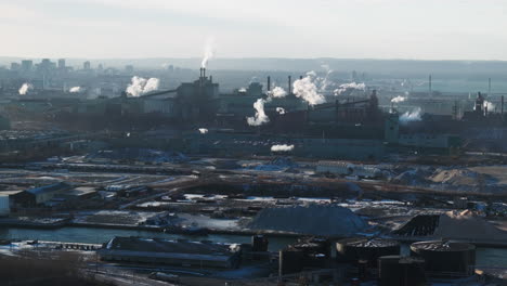 Industrial-landscape-with-smokestacks-against-a-city-backdrop,-highlighting-environmental-impact