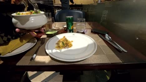 A-south-east-asian-waiter-serving-chicken-dum-biryani-on-a-plate-in-Grill-Punjab-restaurant-in-Cyberhub,-Gurgaon