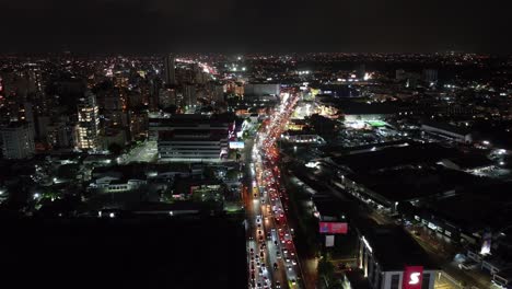 Luftaufnahme-Von-Santo-Domingo,-Dominikanische-Republik-Bei-Nacht,-Autobahnverkehr,-Zentrale-Gebäude-Und-Lichter-Der-Stadt