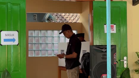 Hombre-Emitiendo-Voto-En-Las-Elecciones-Presidenciales-De-Indonesia,-Oficial-De-Supervisión-Presente