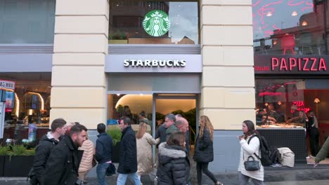 Fußgänger-Gehen-An-Der-Amerikanischen-Multinationalen-Starbucks-Kaffeekette-In-Einer-Belebten-Einkaufsstraße-In-Spanien-Vorbei