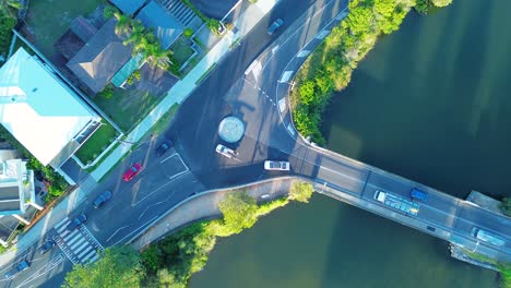 Drone-aerial-cars-traffic-driving-across-bridge-roundabout-on-busy-street-rural-town-Terrigal-bridge-infrastructure-Wamberal-Central-Coast-Australia