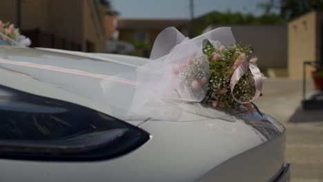 Toma-En-Cámara-Lenta-De-Adornos-Florales-De-Boda-Ondeando-En-El-Viento-De-Un-Automóvil