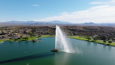 Drone-retreats-upward-above-Fountain-Hills-central-lake-at-midday,-Arizona