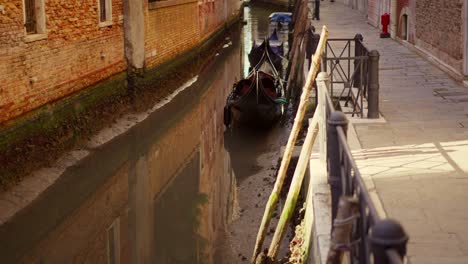 Tilt-camera-movement-on-a-dry-canal-in-Venice,-Italy