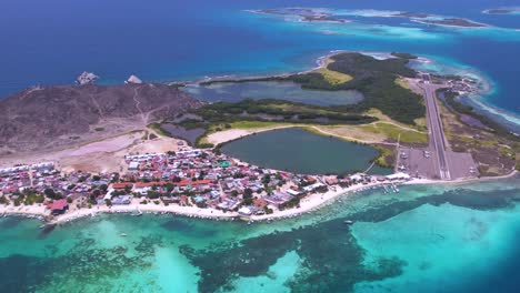 Dolly-in-Gran-Roque-village,-aerial-shot-colorful-tropical-island-caribbean-sea