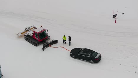 View-from-above-of-snowcat-evacuate-car-from-Lungauring-race-track,-Austria