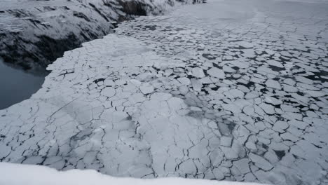 Slow-motion-POV-of-a-winter-ferry-boat-ride-in-Geirangerfjord-to-Geiranger,-Norway,-showcasing-ice-floating-from-mountains-in-the-fjord