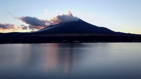 Majestätischer-Fuji-In-Der-Abenddämmerung-Mit-Ruhigem-Seewasser,-Das-Den-Heiteren-Himmel-Widerspiegelt,-Ruhige-Stimmung