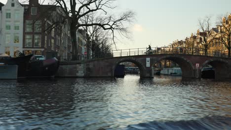 Amsterdam-canal-scene-with-historic-architecture,-bridges-and-and-houseboats