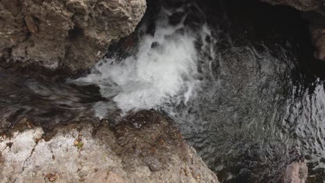 Una-Vista-Fija-Desde-Arriba-De-Una-Mini-Cascada-Entre-Rocas