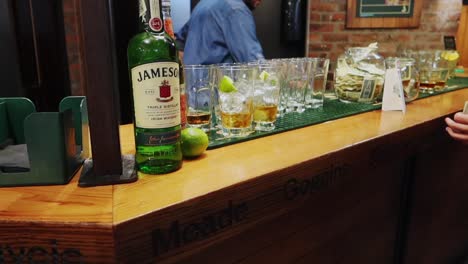 Bartender-arm-serving-a-drink-in-a-glass-with-a-lemon-wedge