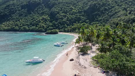 Verankerte-Boote-Mit-Besuchern,-Die-Den-Malerischen,-Von-Palmen-Gesäumten-Playa-Ermitano-Erkunden