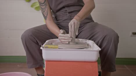 Clay-worker-dips-hands-in-water-to-wet-and-deftly-form-clay-pot-on-rotating-wheel