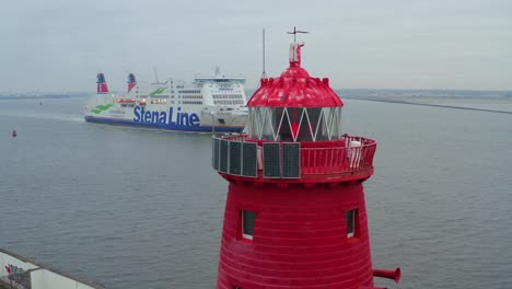 Langsame-Drohne-Umkreist-Das-Rot-Flackernde-Licht-Des-Leuchtturms-Von-Poolbeg-Mit-Einem-Kreuzfahrtschiff,-Das-In-Den-Hafen-Von-Dublin-Einläuft