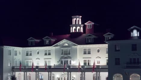 Banderas-Americanas-Exhibidas-Con-Orgullo-Sobre-La-Entrada-Del-Antiguo-Hotel-Blanco-De-Estilo-Colonial-Por-La-Noche