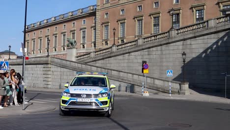 Schwedische-Polizeiautos-Vor-Dem-Königspalast-Mit-Zuschauern,-Sonniger-Tag