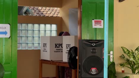 Woman-casting-vote-in-Indonesian-presidential-election,-indoor,-privacy-booth