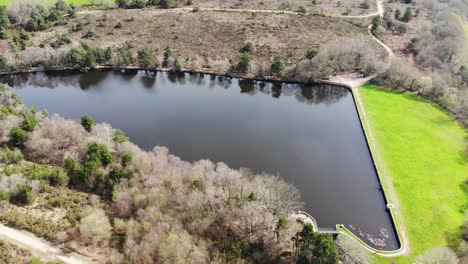 Flying-Over-Calm-Squabmoor-Reservoir-Located-In-Woodbury-Common