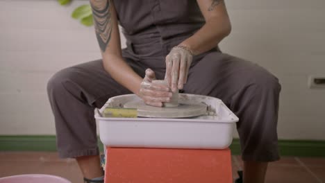 Studio-potter-demonstrates-pulling-and-shaping-clay-pot-on-rotating-turntable