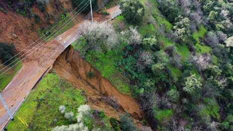 Aerial-view-of-a-landslide-at-a-road-in-the-mountains-of-rainy-California,-USA