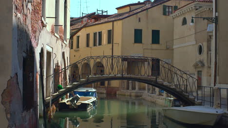 En-El-Corazón-De-Venecia,-Italia,-Un-Puente-Cruza-Un-Pintoresco-Canal-En-Un-Barrio.