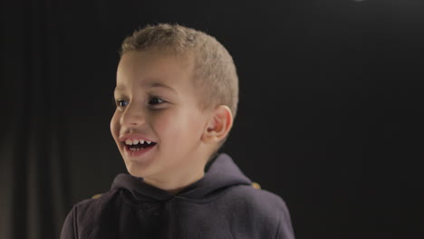 Kleiner-Junge-Lächelt-Und-Zeigt-Verschiedene-Gesichtsreaktionen-Auf-Die-Kamera,-Während-Er-Ein-Filmcasting-Und-Einen-Kameratest-Macht,-Aufgenommen-In-4K